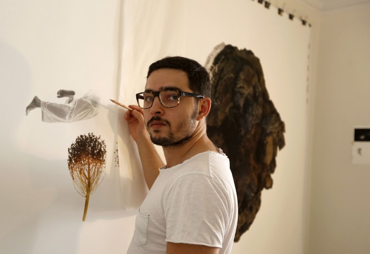 Iranian artist Nima Zaare-Nahandi, 34, gestures during an interview with AFP at his house in Tehran on September 23, 2017. 