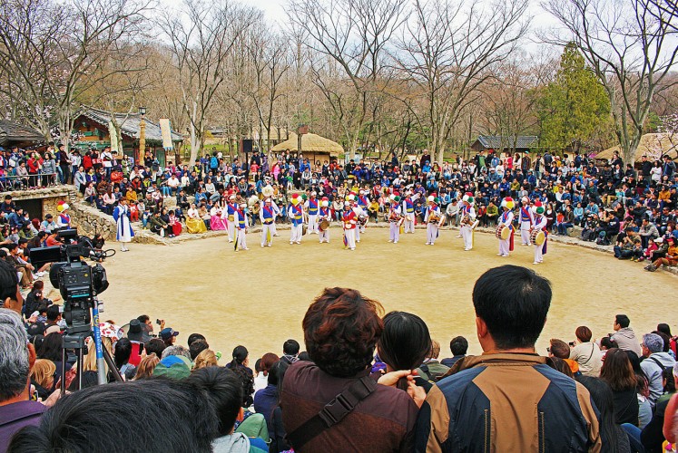 The show begins: Visitors flock to a small amphitheater to enjoy a farmer’s dance.