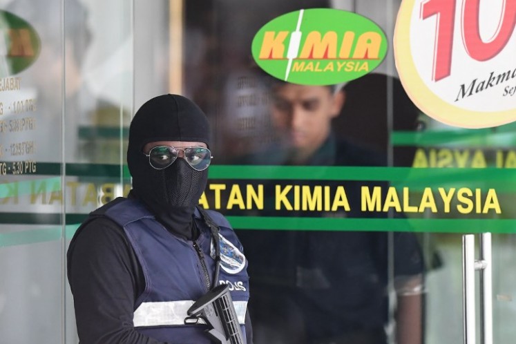 A Royal Malaysian Police officer stands guard at the main entrance of the Malaysian Chemistry Department following the arrival of accused Indonesian Siti Aisyah and Vietnamese Doan Thi Huong to the premises in Petaling Jaya, outside Kuala Lumpur on Oct. 9, 2017, as part of the ongoing trial for two women involved in the assassination of Kim Jong-Nam, the half-brother of North Korean leader Kim Jong-Un. The two accused, Indonesian Siti Aisyah and Vietnamese Doan Thi Huong, were brought to the department to view clothing said to be tainted with a nerve agent and other related chemicals that was used to kill Kim. 