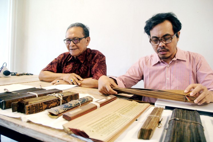 Experts: Ida I. Dewa Gde Catra (left) and Sugi Lanus expound the narrative on Mt. Agung written in ancient lontar (palm-leaf manuscripts).
