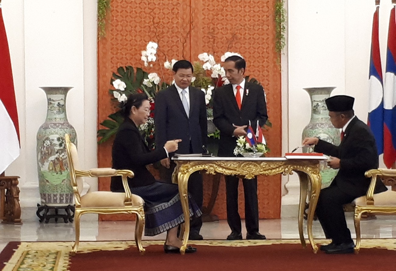 Laos Education and Sports Minister Sengdeuane Lachanthaboun (left) and Culture and Education Minister Muhadjir Effendy sign a memorandum of understanding (MoU) on education cooperation, witnessed by Laos Prime Minister hongloun Sisoulith (second left) and President Joko "Jokowi" Widodo, at Bogor Palace in West Java on Oct. 12. Image: Anton Hermansyah | Jakarta Post