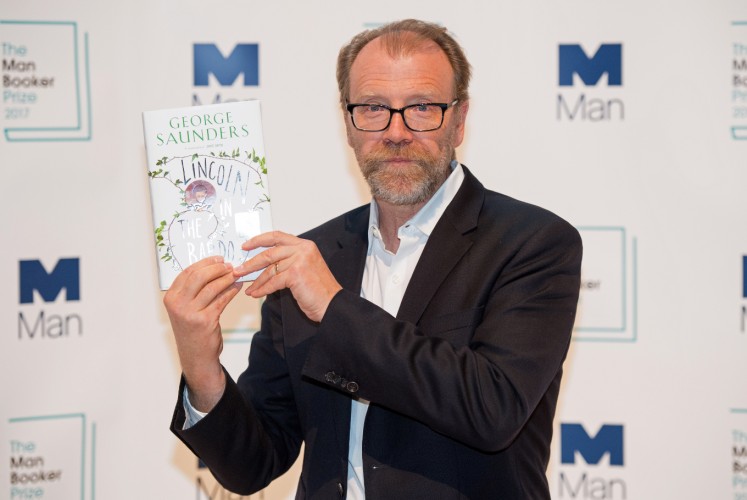 US author George Saunders poses with his book 'Lincoln in the Bardo' during a photocall at the Royal Festival Hall in London on October 16, 2017, ahead of tomorrow's announcement of the winner of the 2017 Man Booker Prize for Fiction. 