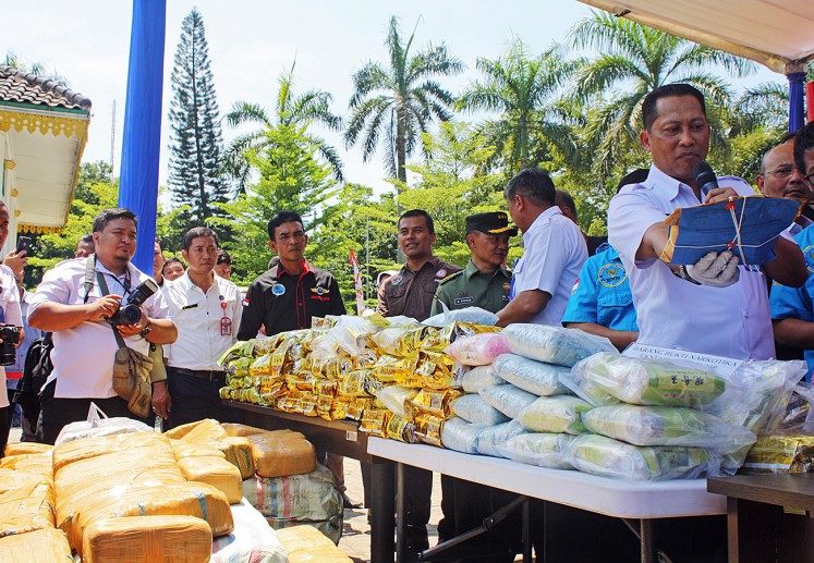 National Narcotics Agency (BNN) chief Comr. Gen. Budi Waseso (right) holds a package of crystal methamphetamine at Merdeka Square in Medan, North Sumatra, on Thursday. Drugs seized during police operations, including 191 kilograms of crystal meth, 43,000 ecstasy pills and 500 kg of marijuana, were destroyed at the square.