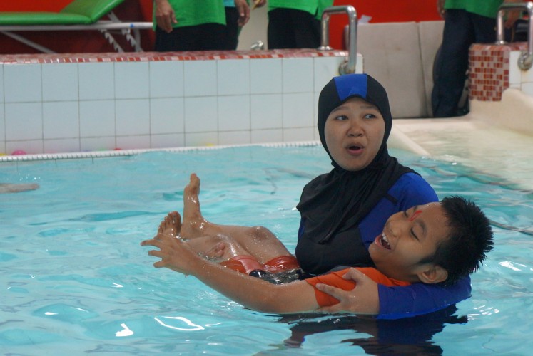 A young man with cerebral palsy joins the Aquatic activity.