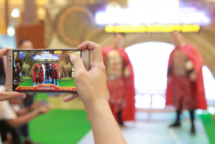 Indonesian actor Billy Davidson (left) and YouTube content creator Chandra Liow (right) try out the augmented reality photo technology at Disney×Marvel Studios' 'Thor: Ragnarok' exhibition at Pacific Place, South Jakarta.