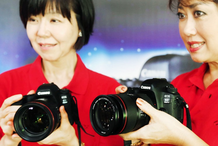 Introduction: Canon Singapore President and Chief Executive Officer Noriko Gunji (left) and Merry Harun, the Canon division director of PT Datascrip, the Indonesian sole distributor of Canon cameras, test the new camera.