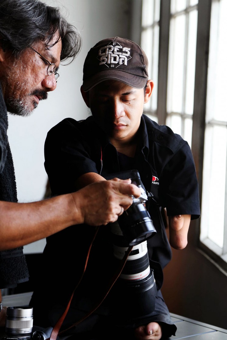 Watch and learn: Photographer Darwis Triadi (left) shares some snaps with Dzoel.