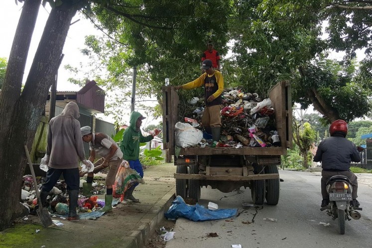 Workers pick up rubbish from the streets of Kendari in eastern Indonesia's Sulawesi province twice a day. Some of the sorting work takes place on the trucks.