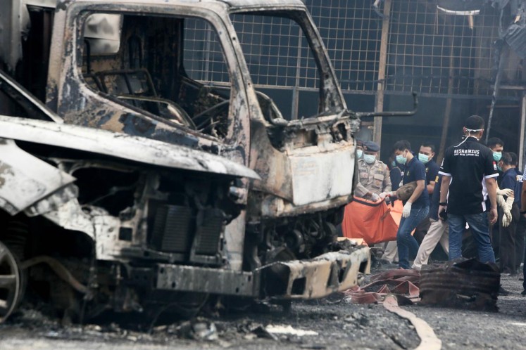 Officers evacuate victims at the fireworks factory blaze in Kosambi, Tangerang, on Thursday. 