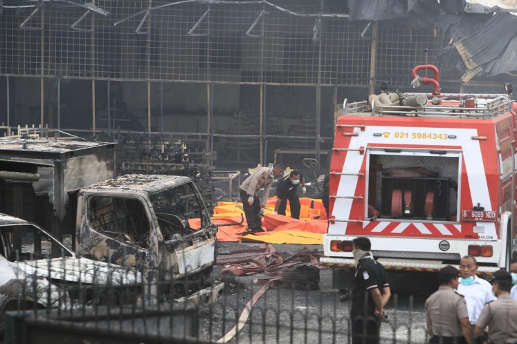 Officers prepare body bags to carry bodies of victims of the fireworks factory blaze in Kosambi, Tangerang on Thursday. 