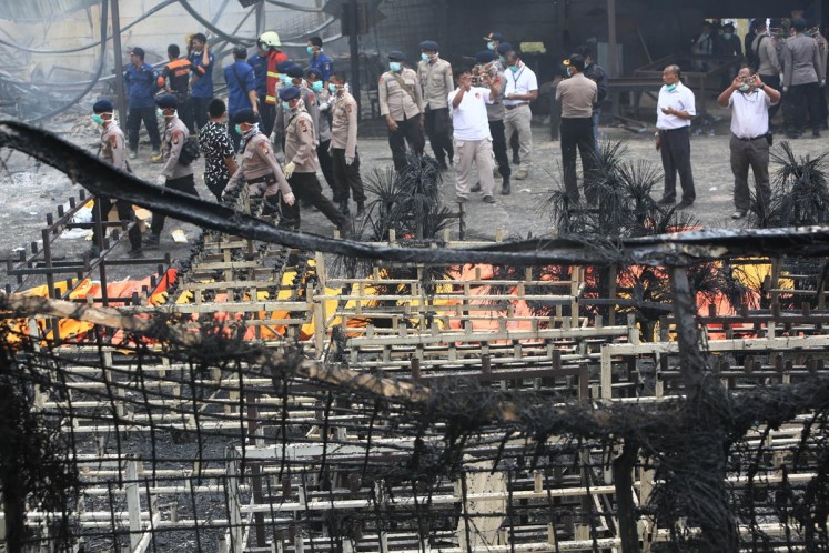 Officers evacuate victims of the fireworks factory blaze in Kosambi, Tangerang on Thursday. 