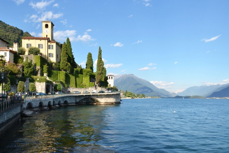 Lake Como is a town surrounded by sparkling blue calm water. 