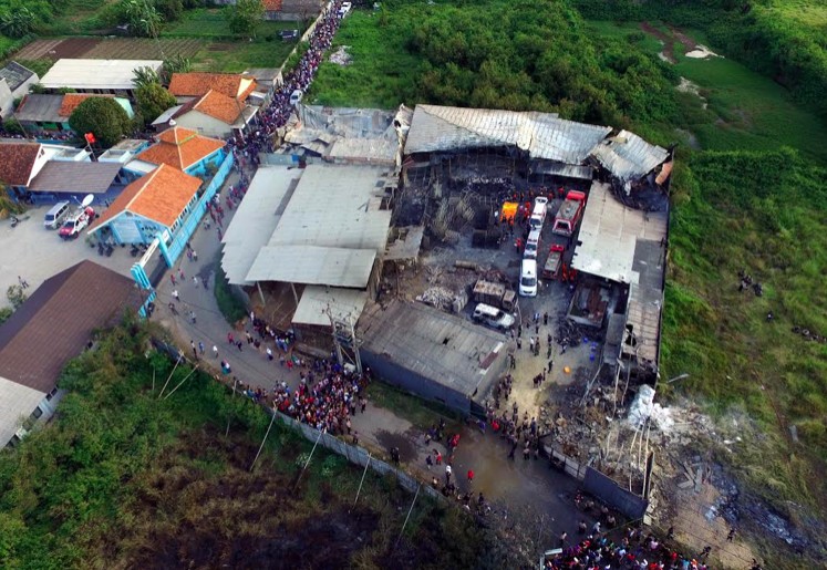 Residents are seen gathering outside the damaged fireworks factory in Kosambi, Tangerang on Thursday. The inferno killed 47 people and injured 46 others. 