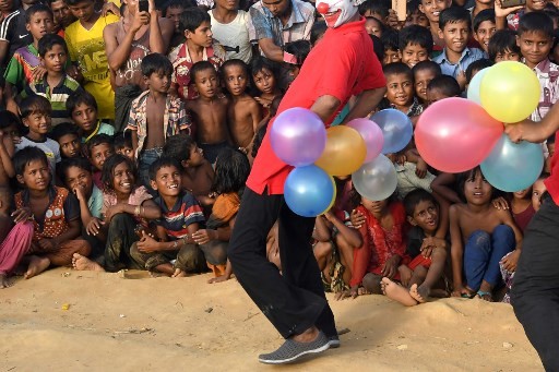 This photograph taken on October 28, 2017 shows Rohingya refugee children watching the Bangladeshi theatre group 