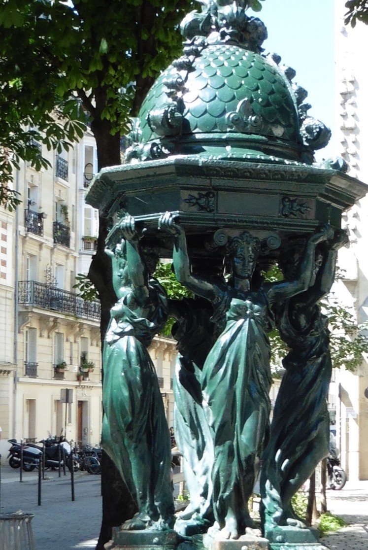 In the center of the square is a drinking-water fountain, one of more than a hundred to be erected in Paris after 1870. 
