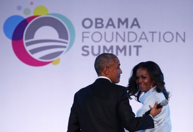 Former US president Barack Obama and his wife Michelle walk off the stage at the Obama Foundation Summit in Chicago, Illinois, Oct. 31, 2017. 