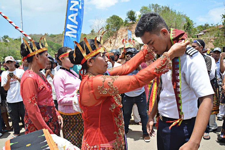 Paying respect: Resto Thomas Aquino Jehabut (right) receives a traditional scarf in a ceremony to pay respect to his naming as the first and youngest pilot from West Manggarai, East Nusa Tenggara, and Malakiri in North Toraja, South Sulawesi. 