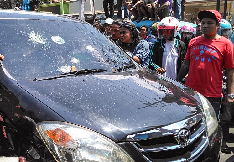 The windshield of a minivan is shattered during a protest in front of the South Sulawesi Governor’s Office in Makassar on Wednesday. The demonstration turned ugly after hundreds of protesters, mostly angkot (public minivan) and motorized becak (pedicab) drivers, began throwing rocks at cars believed to be employed by online ride-hailing companies.