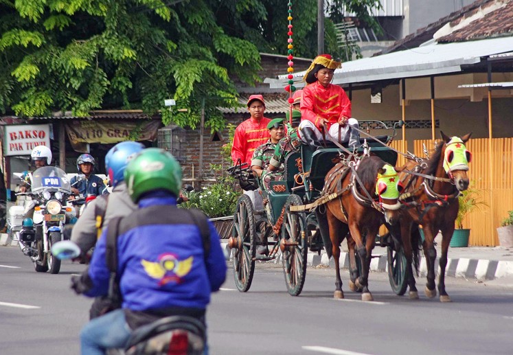 Trial run: Escorted by police officers, coachmen take out a horse-drawn carriage that will be used to escort the bride and groom and their families to Graha Saba Buana, where the wedding of First Daughter Kahiyang Ayu and Muhammad Bobby Afif Nasution will take place in Surakarta on Wednesday.  