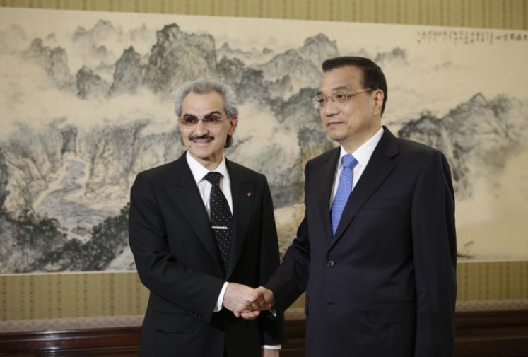 In this file photo, Saudi Prince Alwaleed bin Talal (left) shakes hands with China's Premier Li Keqiang (right) during their meeting at Zhongnanhai in Beijing on May 18, 2016. 