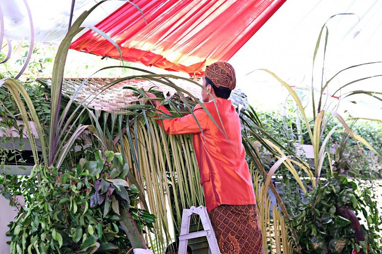 President Joko 'Jokowi' Widodo hangs bleketepe (row of plaited coconut leaves) in front of his private residence on Jl. Kutai Utara, Sumber, Surakarta, Central Java, on Nov. 7, 2017.