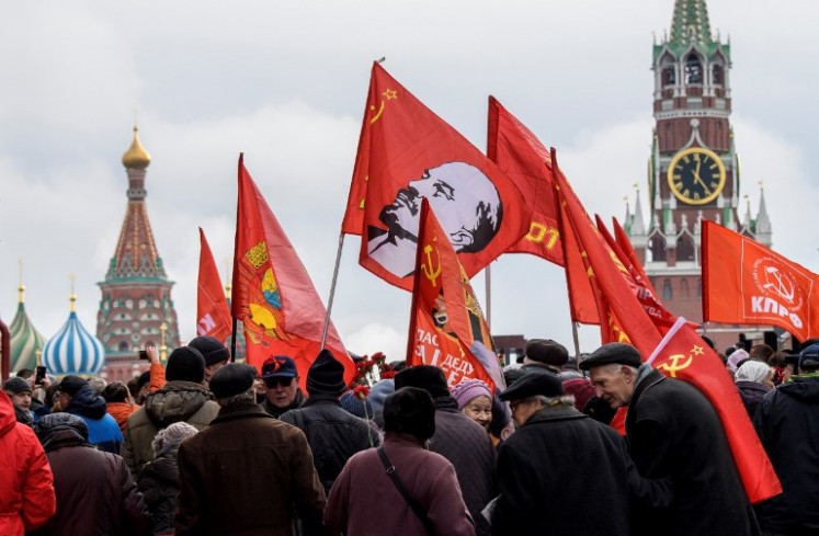Russian Communist supporters walk along the Red square to lay flowers at Lenin's mausoleum in Moscow on Nov. 5, 2017, to celebrate the forthcoming 100th anniversary of The Bolshevik Revolution. Russia is set to hold low-key events to mark a century since the 1917 Bolshevik Revolution on Nov. 7, with authorities uncertain how to assess the uprising that led to 70 years of Communist rule.