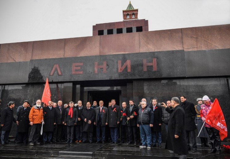 Russian Communists pose for a picture after laying flowers at Lenin's mausoleum on the Red square in Moscow on Nov. 5, 2017, to celebrate the forthcoming 100th anniversary of The Bolshevik Revolution. Russia is set to hold low-key events to mark a century since the 1917 Bolshevik Revolution on Nov. 7, with authorities uncertain how to assess the uprising that led to 70 years of Communist rule.
