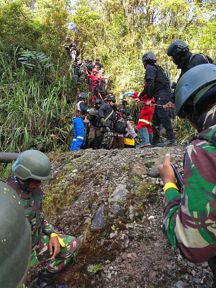Deadly incident: Officers of the Papua Police’s Mobile Brigade (Brimob), supported by Indonesian Military personnel, take the body of Brig. Firman, a police officer shot and killed on Wednesday, to the hospital. 