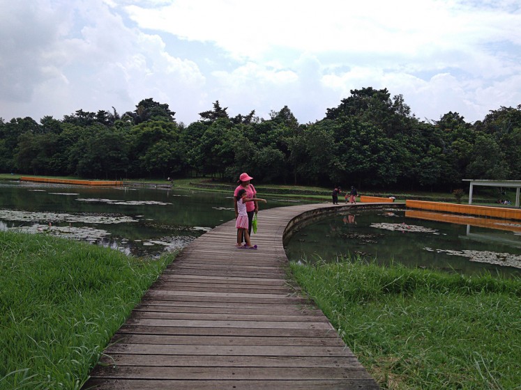 Boardwalk: Visitors explore an artificial lake at the Ecology Park, Cibinong Science Center in Bogor regency, West Java.