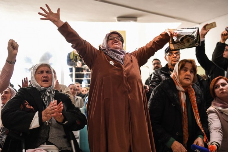People celebrate as they watch a live TV broadcast from the International Criminal Tribunal for the former Yugoslavia (ICTY) on Nov. 22, 2017 in Srebrenica, when UN judges announce the life sentence in the trial of former Bosnian Serbian commander Ratko Mladic, accused of genocide and war crimes in the brutal Balkans conflicts over two decades ago. 