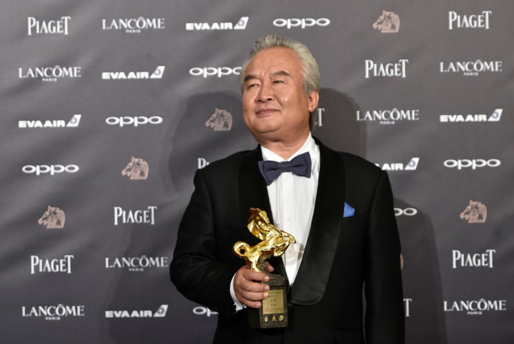 Chinese actor Tu Men poses after winning the Best Leading Actor Award for his film 