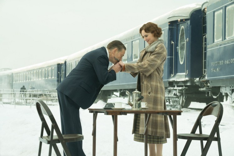 Detective Hercules Poirot (Kenneth Branagh, left) interacts with one of the passengers of the Orient Express, Mary Debenham (Daisy Ridley).