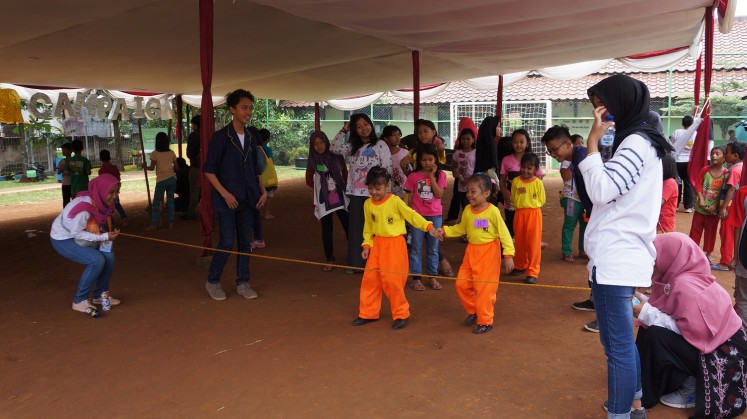 Children play 'lompat tali karet' during the Traditional Games Return Campaign at RPTRA Cililitan in East Jakarta. 