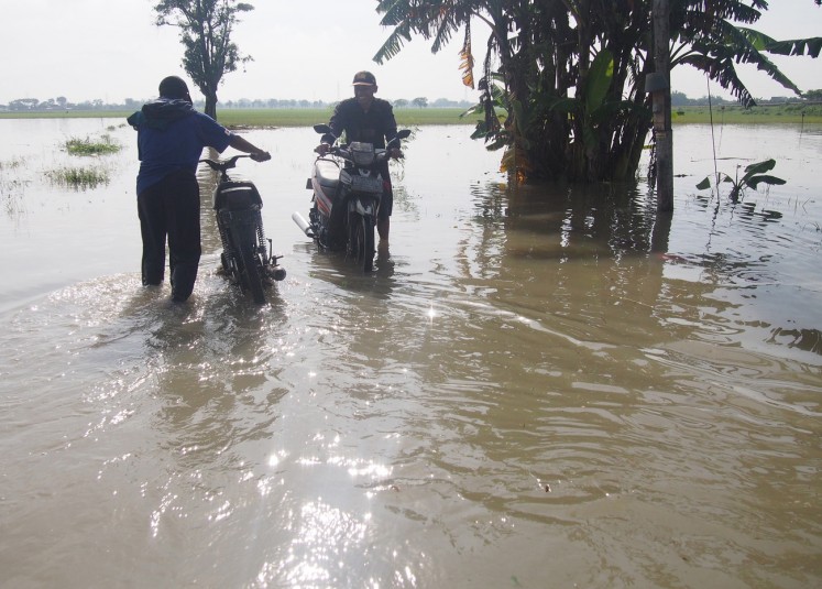 In crisis: Residents wade through a flooded road in Gadingan village, Mojolaban, Sukoharjo, Central Java, on Nov.29.
