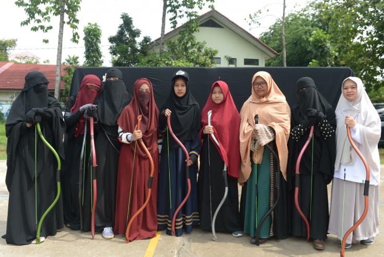 This picture taken on November 12, 2017 shows Indonesian Muslim women posing for a photograph after participating in archery and horse riding lessons in Bekasi. Riding a horse or nailing an archery target is tough at the best of times -- it's even harder when you're wearing a niqab. But that isn't about to stop a group of Indonesian women who have banded together as they face prejudice against the face-covering veil at the centre of a heated global debate over religious freedom and women's rights.