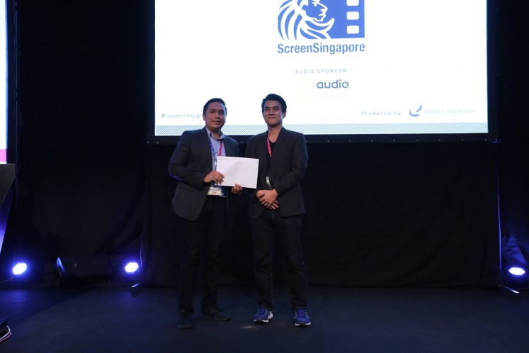 'The Hunted' producer Delon Tio (left) receives the award at the third Southeast Asian Film Financing (SAFF) Project Market in Singapore on Dec. 1.
