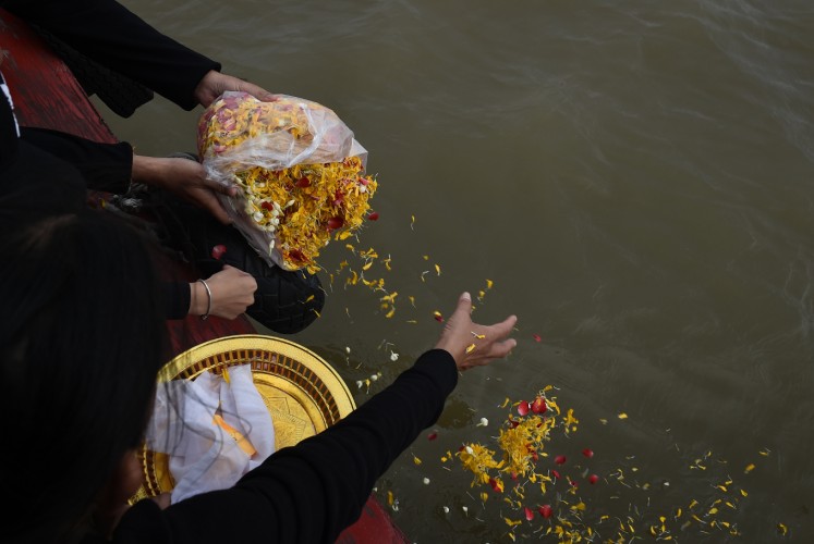 This photo taken on November 5, 2017 shows a family of mourners releasing flowers with the bones and ashes of their beloved pet dog into the Chaopraya river in Bangkok. Pet cremations, complete with Buddhist rituals, are popping up across Bangkok for dogs, cats and even monkeys. In a devout Buddhist kingdom where religion and superstitious beliefs entwine, some pet owners believe the monk-led send off will boost their pets' chances of being reincarnated as a higher being.
