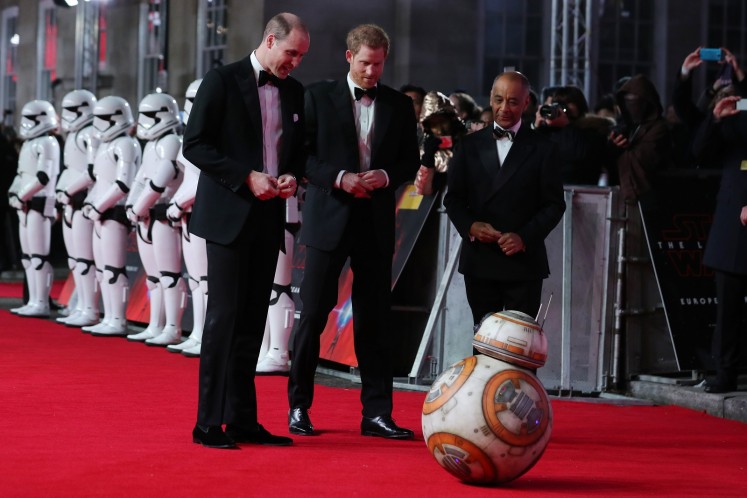 Britain's Prince William (L), Duke of Cambridge and Prince Harry are greeted by droid BB-8 as they arrive for the European Premiere of Star Wars: The Last Jedi at the Royal Albert Hall in London on December 12, 2017. 