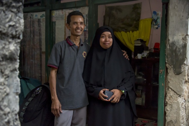This photograph taken on October 24, 2017 shows Sriyono (L), who suffers from asbestosis - scarring of the lungs from breathing in asbestos fibres, posing with his wife in front of his house in Cibinong, West Java province. 