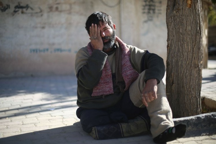 A man poses covering one eye with his hand in the rebel-held town of Douma in Syria's besieged eastern Ghouta region, on Dec. 18, 2017, as part of a campaign in solidarity with a baby boy, Karim Abdallah, who lost an eye, as well as his mother, in government shelling on the nearby town of Hammouria.