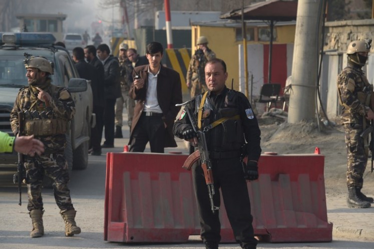 Afghan security personnel keep watch near the site of a suicide attack in Kabul on December 25, 2017. A suicide attacker on foot blew himself up near a compound belonging to the Afghan intelligence agency in Kabul on December 25, killing six civilians, officials said.
