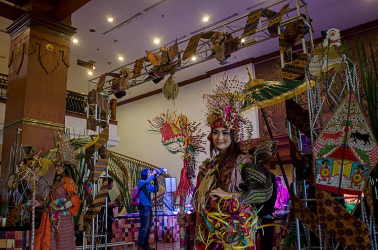 Preserving culture: Models in colorful attire made from traditional fabric pose for photographs at an event at Sunan Hotel in Surakarta, Central Java.