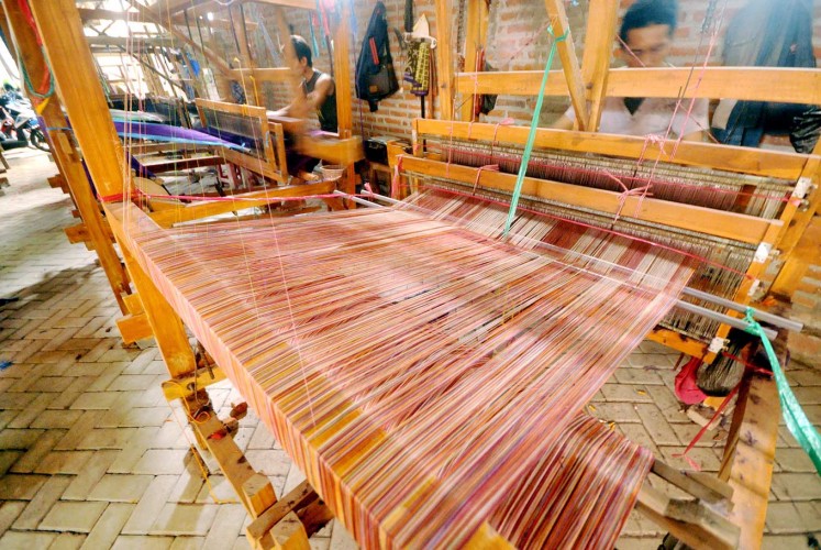 Gender equality: Men work with manual weaving looms in Bandar Kidul subdistrict, Kediri, East Java.