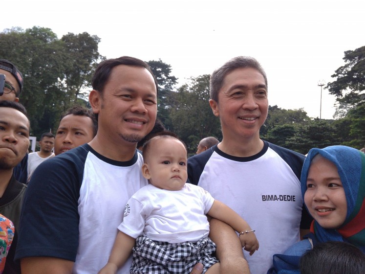 All set: Incumbent Bogor mayor candidate Bima Arya (left) and his running mate, Dedie A.Rachim (right), take a picture with residents at Sempur Field, Bogor, West Java, on Sunday.