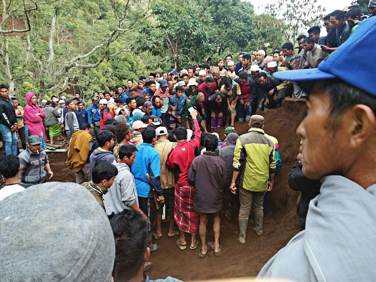 Rescue efforts: Residents help evacuate victims of the landslide on Wednesday.