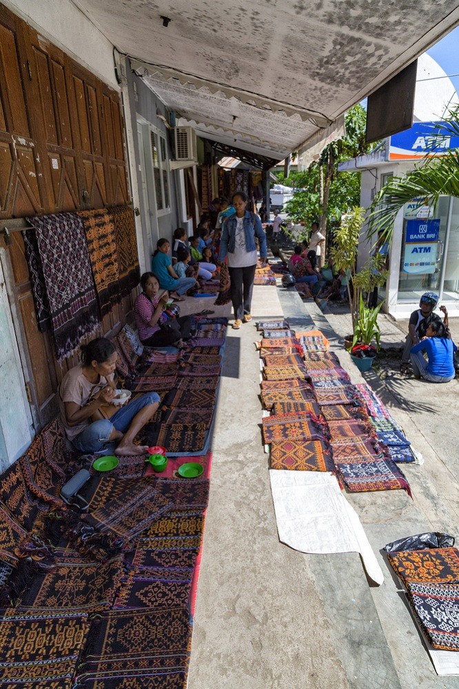 Merchants selling traditional fabrics in Maumere market.