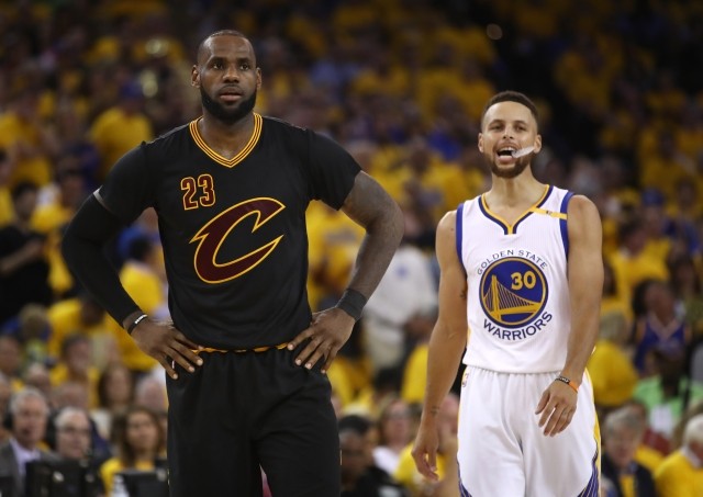 LeBron James (left) of the Cleveland Cavaliers and Stephen Curry (right) of the Golden State Warriors look on during the first half in Game 5 of the 2017 NBA Finals at ORACLE Arena on June 12, 2017 in Oakland, California.