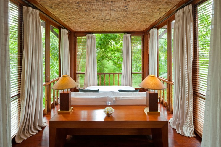 The Estate's Wanakasa Terrace Suite features a bedroom surrounded by floor to ceiling windows.