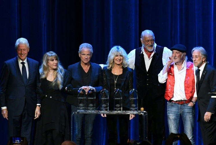 (From L-R) Former US president Bill Clinton, Stevie Nicks, Lindsey Buckingham, Christine McVie, Mick Fleetwood, John McVie and Recording Academy president Neil Partnow pose on stage at the 2018 MusiCares Person Of The Year gala at Radio City Music Hall in New York on January 26, 2018. The 2018 MusiCares Person of the Year award was presented to Fleetwood Mac at the 28th annual MusiCares Gala Tribute dinner and concert ahead of Sunday's 60th GRAMMY Awards, marking the first time the benefit has honored a band. Proceeds from the event go towards MusiCares.