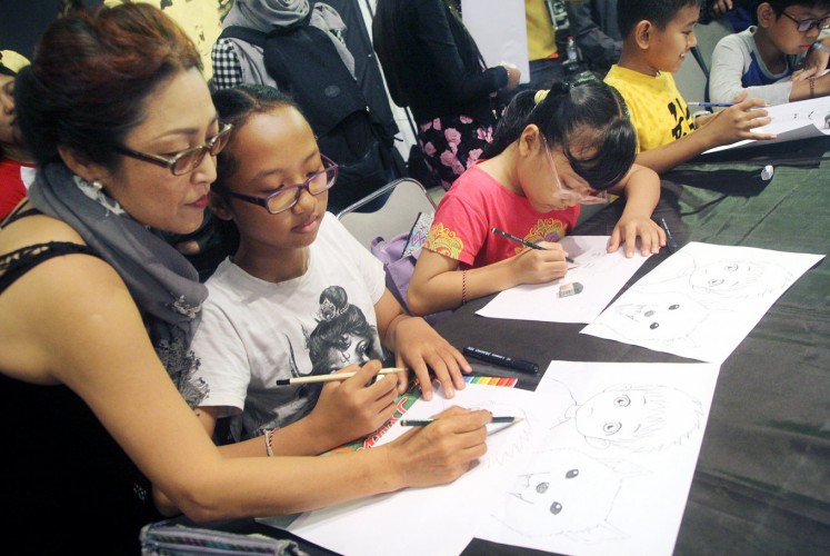 Cultivating creativity: Japanese manga artist Tamiko Tsuneoshi teaches children how to draw during a manga workshop at Bentara Budaya Bali on Saturday.
